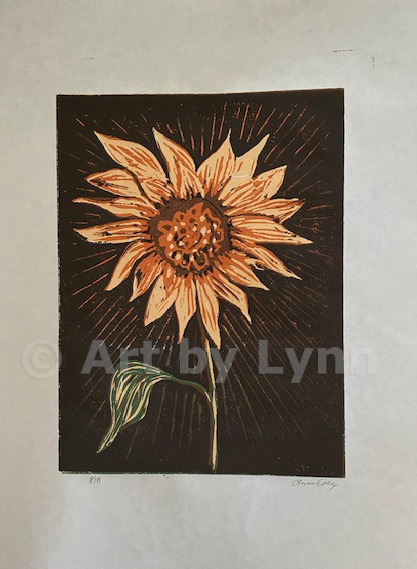 Linocut reduction print of a sunflower with brown background.