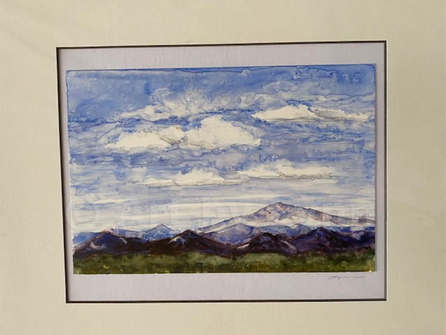 Watercolor of a mountain scape with blue skies and white clouds.