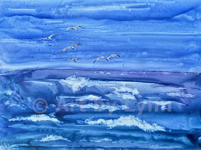 Watercolor of seagulls flying in the air over the ocean, on Yupo paper.